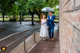 Rosario, Argentina, is the setting for the bride and groom as they arrive at their ceremony, sheltering together under a single umbrella on a rainy day.